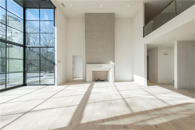 unfurnished living room featuring a large fireplace and a high ceiling