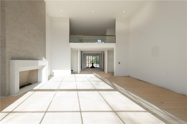 corridor featuring light hardwood / wood-style flooring and a high ceiling