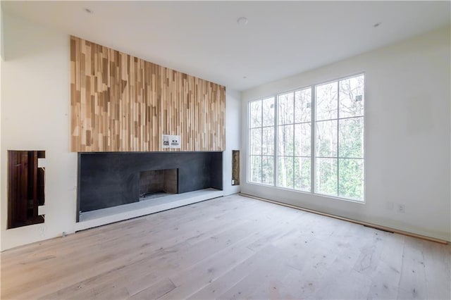 unfurnished living room with wood-type flooring and a wealth of natural light