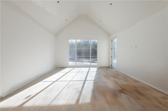 spare room featuring light hardwood / wood-style flooring, high vaulted ceiling, and plenty of natural light