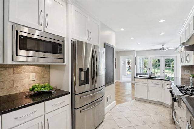 kitchen with white cabinetry, backsplash, and stainless steel appliances