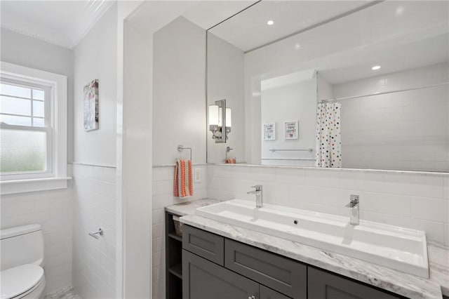 bathroom featuring tile walls, vanity, toilet, and walk in shower