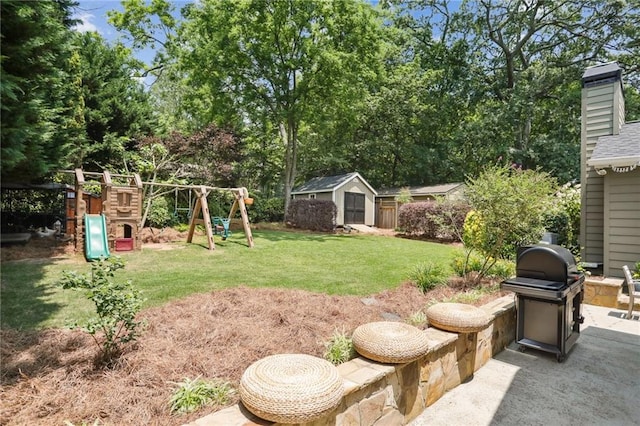 view of yard with a shed, a patio area, and a playground