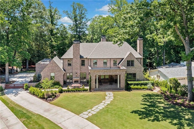 3146 Frontenac Ct NE, Atlanta, GA 30319 - view of front of home featuring a chimney, a front lawn, brick siding, view of wooded area, and roof with shingles