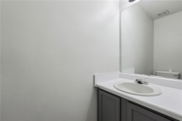 2205 Dresden Grn NW, Kennesaw, GA 30144 - half bathroom featuring visible vents, toilet, a textured ceiling, and vanity