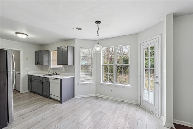 2205 Dresden Grn NW, Kennesaw, GA 30144 - kitchen featuring white dishwasher, freestanding refrigerator, gray cabinetry, a sink, and light countertops