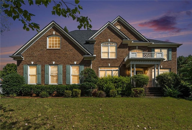 view of front of house with a yard and a balcony