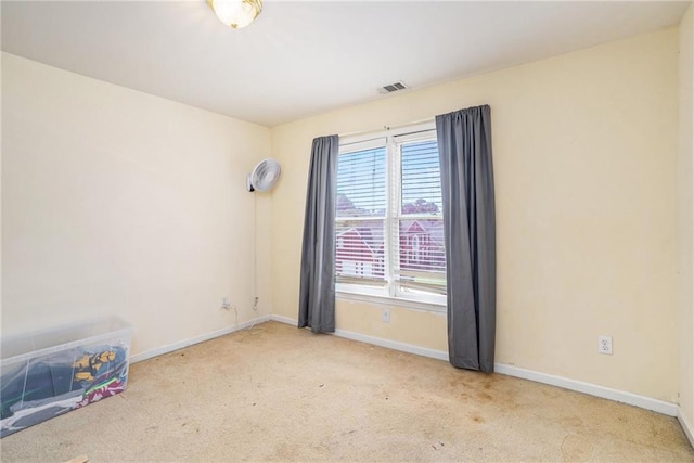 spare room featuring light colored carpet