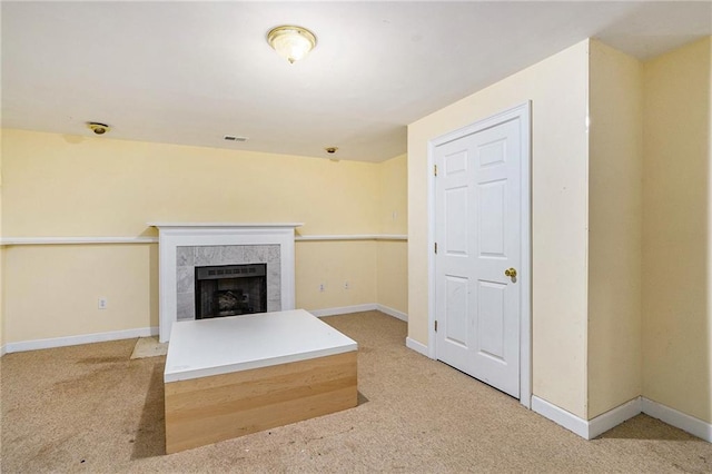 unfurnished living room with a tile fireplace and carpet floors