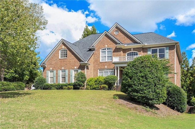 view of front of house featuring a balcony and a front lawn