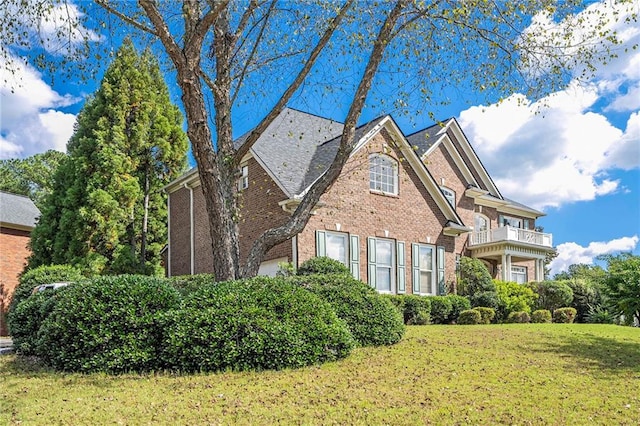 view of front of home featuring a balcony and a front lawn