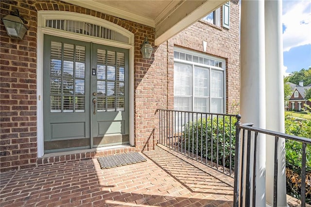 view of exterior entry featuring french doors and a porch