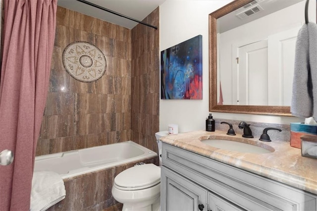 full bath featuring toilet, vanity, shower / bath combo with shower curtain, and visible vents