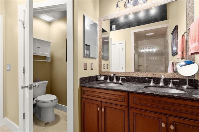 bathroom with tile patterned flooring, a sink, a shower stall, and toilet