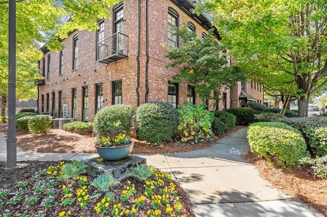 view of side of home featuring brick siding and central air condition unit