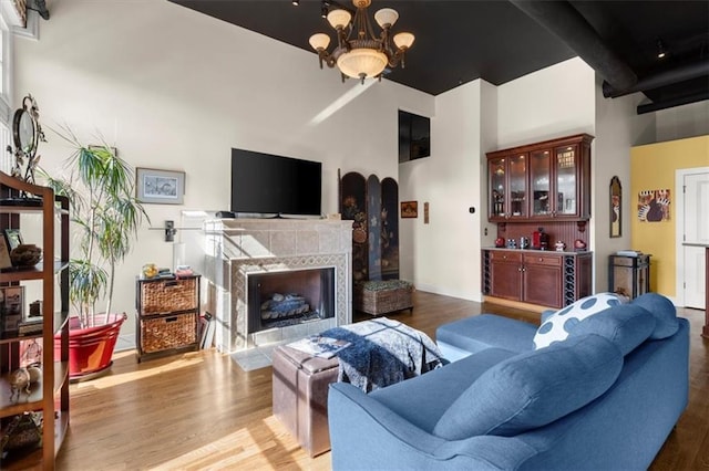 living area with a chandelier, a premium fireplace, and wood finished floors