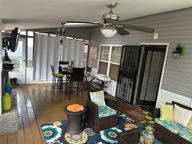 sunroom / solarium featuring ceiling fan