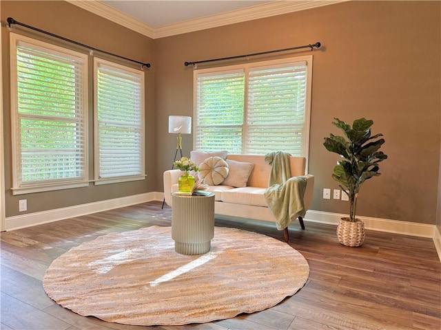 sitting room featuring baseboards, ornamental molding, and wood finished floors