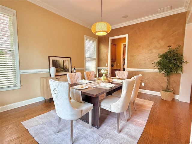 dining room featuring crown molding, wood finished floors, and a wealth of natural light