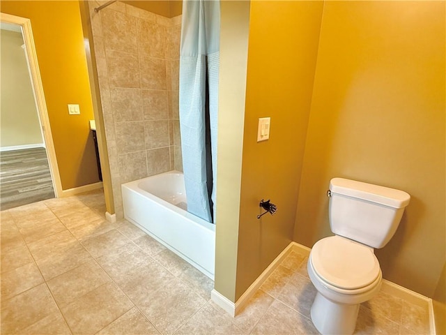 full bathroom with baseboards, shower / tub combo with curtain, tile patterned floors, and toilet