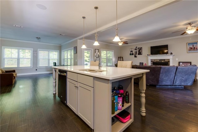 kitchen with decorative light fixtures, a kitchen island with sink, sink, and a wealth of natural light