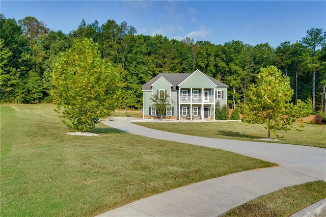 view of front of house featuring a front lawn and a balcony