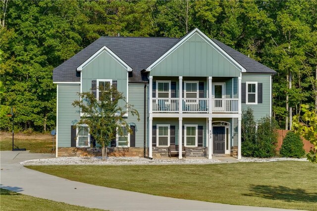 view of front of house with a front yard and a balcony