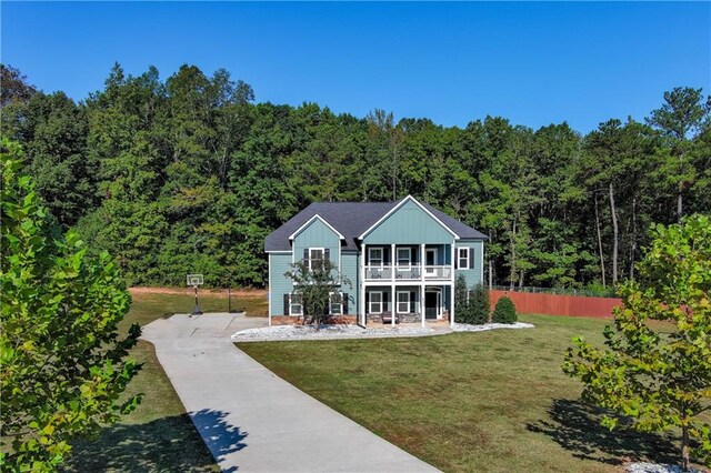 view of front of property with a porch, a balcony, and a front yard