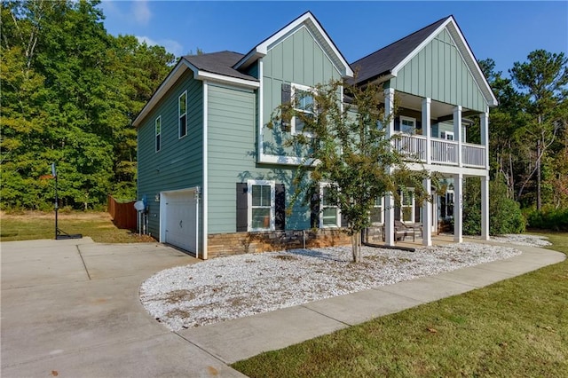 view of front of home featuring a balcony, a garage, and a front lawn