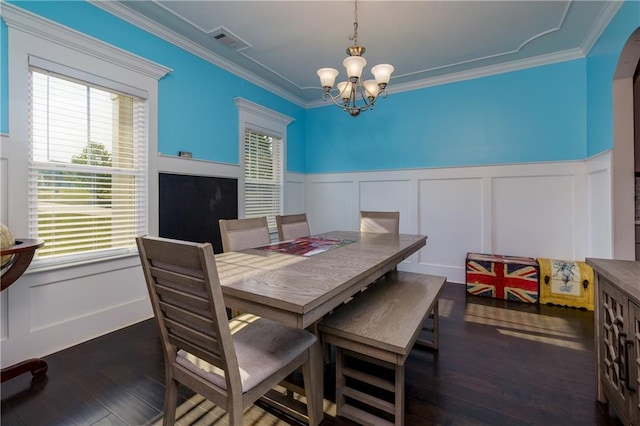 dining room featuring dark hardwood / wood-style floors, a chandelier, and crown molding