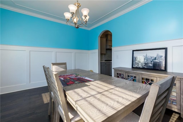 dining area with ornamental molding, a chandelier, and dark hardwood / wood-style floors