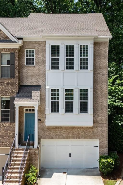 1036 Grant Park Rd, Decatur, GA 30033 - view of front of home featuring brick siding, a garage, driveway, and roof with shingles