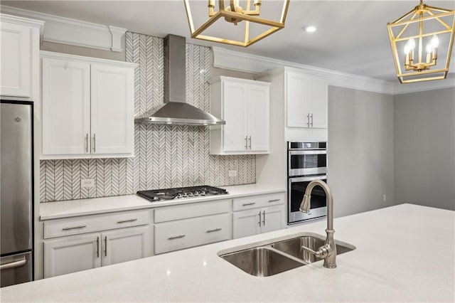 1036 Grant Park Rd, Decatur, GA 30033 - kitchen featuring wall chimney exhaust hood, a chandelier, appliances with stainless steel finishes, white cabinets, and crown molding