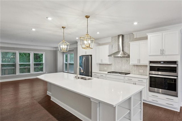 1036 Grant Park Rd, Decatur, GA 30033 - kitchen with wall chimney range hood, appliances with stainless steel finishes, a sink, a center island with sink, and light countertops
