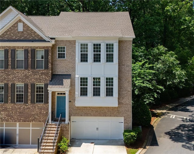 1036 Grant Park Rd, Decatur, GA 30033 - view of front facade featuring an attached garage, brick siding, and driveway