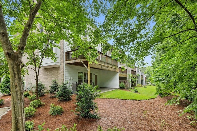 1036 Grant Park Rd, Decatur, GA 30033 - rear view of house with a wooden deck, brick siding, central AC, and a lawn