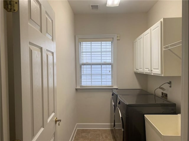 washroom with washing machine and dryer, sink, and cabinets