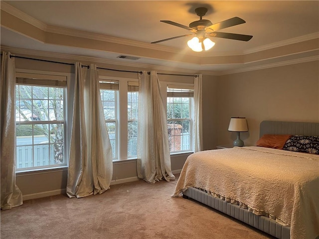 carpeted bedroom with ceiling fan, crown molding, and a raised ceiling