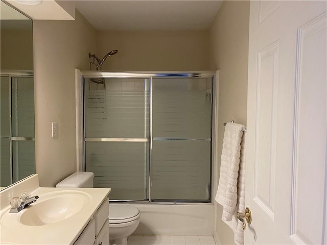 full bathroom featuring toilet, tile patterned flooring, enclosed tub / shower combo, and vanity