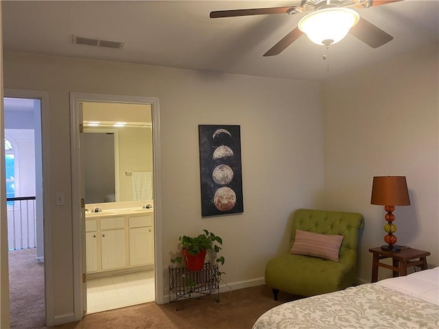 carpeted bedroom with ceiling fan, ensuite bathroom, and sink