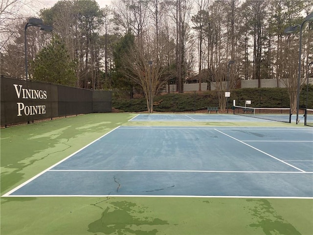 view of tennis court featuring basketball hoop