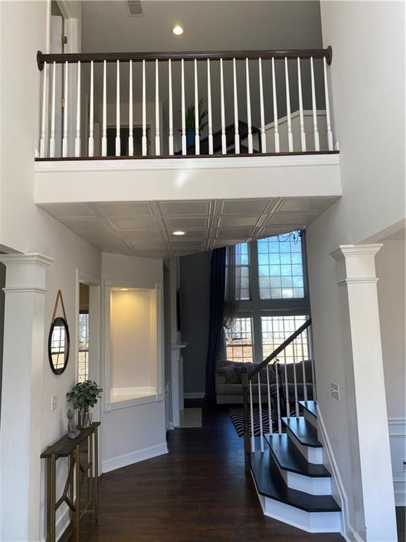 staircase featuring hardwood / wood-style floors and a towering ceiling