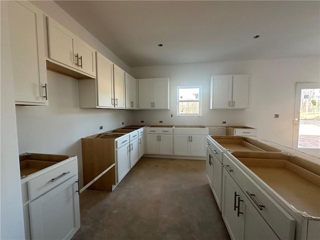 kitchen featuring concrete flooring, white cabinetry, and a kitchen island