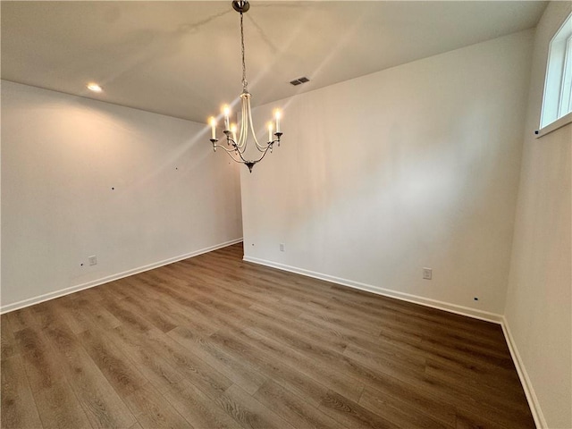 unfurnished dining area featuring visible vents, baseboards, dark wood-type flooring, a notable chandelier, and recessed lighting