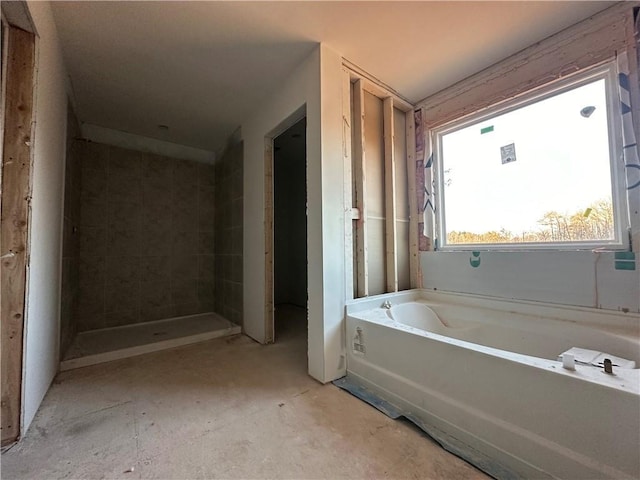 bathroom with a tub and concrete floors