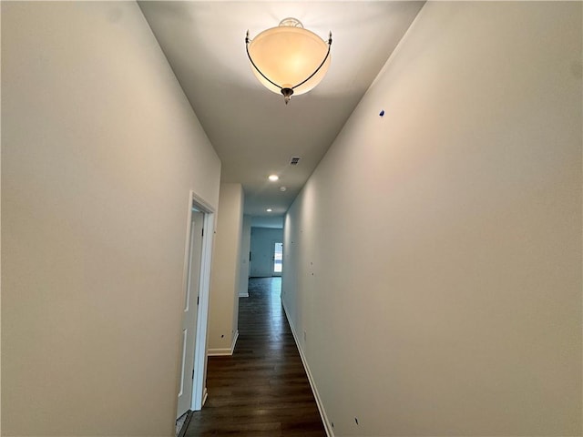 hallway featuring dark wood-style floors, recessed lighting, visible vents, and baseboards