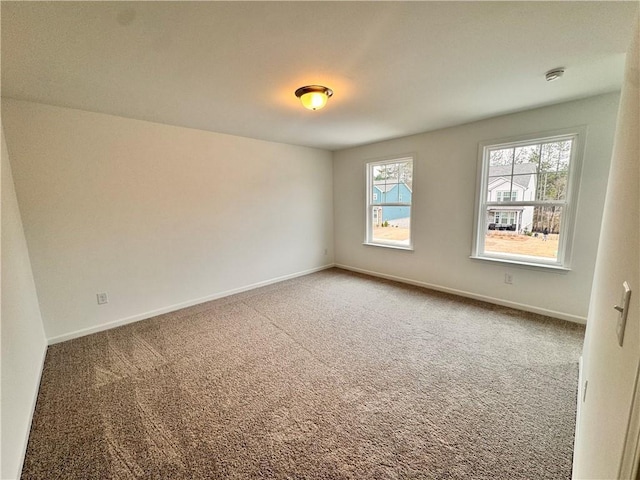 carpeted empty room featuring baseboards