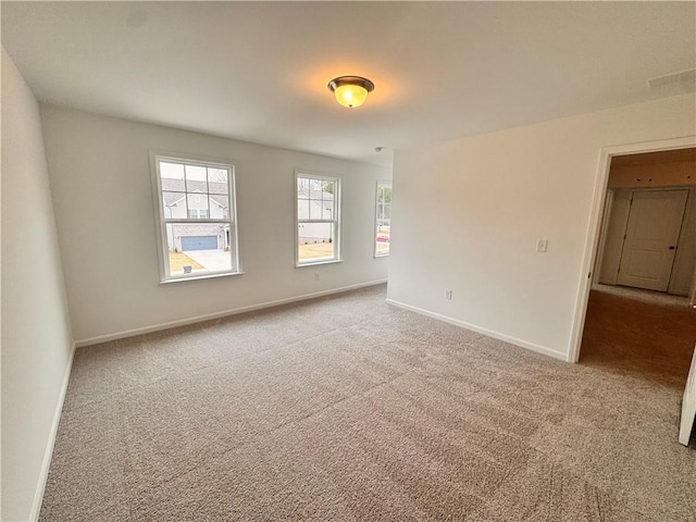 carpeted empty room with baseboards