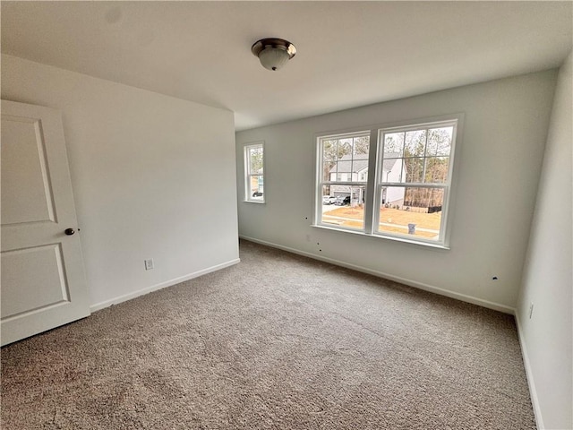 carpeted spare room with baseboards