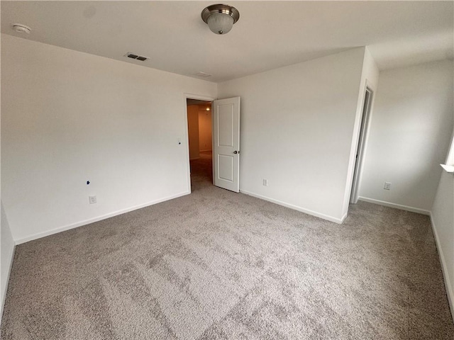 unfurnished bedroom with carpet floors, baseboards, and visible vents